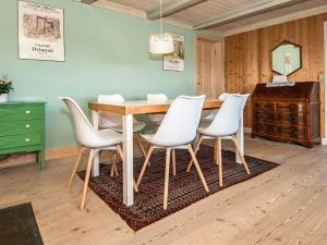 スナーヴィグにある6 person holiday home in Ringk bingのダイニングルーム(テーブル、白い椅子付)