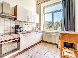 una cocina con armarios blancos y una ventana en Appealing Villa with Garden in Borstendorf Germany, en Leubsdorf