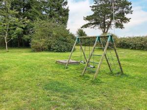 an old swing set in a field of grass at 10 person holiday home in R m in Bolilmark