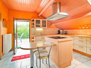 a kitchen with a wooden ceiling and a table at Enjoy a relaxing break for two and discover Durbuy in Biron