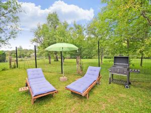two lounge chairs and an umbrella next to a grill at Enjoy a relaxing break for two and discover Durbuy in Biron