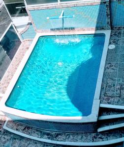 a swimming pool with blue water in a building at Hotel & Suites Bausan in Boca del Río