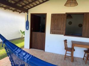 eine Terrasse mit einer blauen Hängematte in einem Haus in der Unterkunft Vila Sol Chalés in Pôrto de Pedras