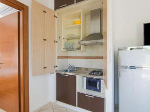 eine kleine Küche mit einer Spüle und einer Mikrowelle in der Unterkunft Engaging Apartment in Riccione with Balcony in Riccione