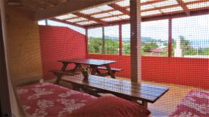 a table and bench in a room with a red wall at Sunset Hill Lodge in Bora Bora