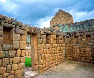 a section of a stone wall with a building at Hotel Chasky in El Tambo