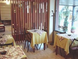 a restaurant with two tables with yellow table cloths at Hotel Dali in San Rafael