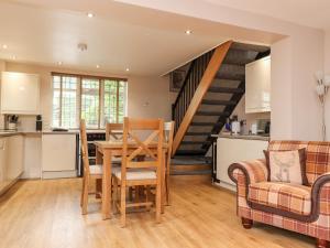 a kitchen and living room with a table and chairs at Mayfield Cottage in Blackpool