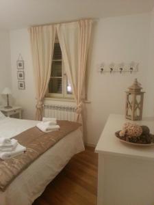 Un dormitorio con una cama y una ventana y una mesa. en Residenza l'Antico Borgo, en Trieste