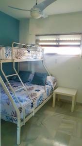 Ce lit superposé se trouve dans un dortoir doté d'une table. dans l'établissement SweetWater Home - Apartamento ideal para tus vacaciones, à El Campillo del Moro