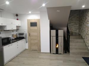 a kitchen with a refrigerator next to a staircase at Domek z jacuzzi Domek u Mrugały in Poronin