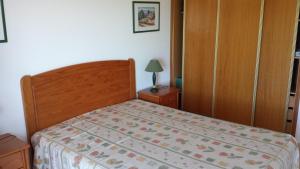 a bedroom with a bed with a bedspread on it at Clube Meia Praia in Lagos