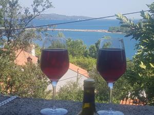 two glasses of wine sitting on a table with a bottle at Extra Spacious Seaview Apartments close to the beach, with large terraces and FREE WI-FI & AC & BBQ & parking space in Sali