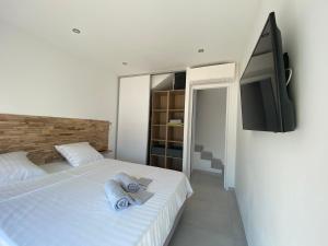 a bedroom with a bed and a flat screen tv at Villa Domaine U Murtonu in Porto-Vecchio