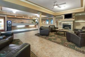 vestíbulo con muebles de cuero y chimenea en Super 8 by Wyndham Fort Saskatchewan, en Fort Saskatchewan