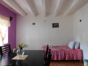 Habitación con mesa y cama de color púrpura en Hotel Elohim by Rotamundos, en Tequisquiapan