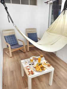 una hamaca con comida en una mesa y 2 sillas en New! Nice FAMILY Apartment with 2 Bedroom, 2 Terrace en Costa da Caparica