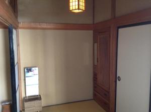 an empty room with a door and a light at Chitosekan in Nozawa Onsen
