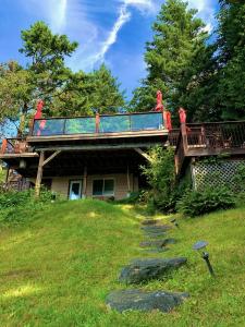 a house with a deck on top of a yard at The Fraser River's Edge B&B Lodge in Chilliwack