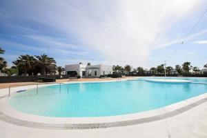 a large swimming pool with blue water at Shalom in Playa Blanca