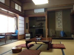 uma sala de estar com uma mesa num quarto em Chitosekan em Nozawa Onsen