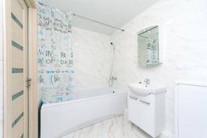 a white bathroom with a tub and a sink at Smart House 11 in Kyiv +48 photos
