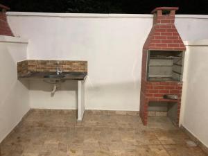 a bathroom with a sink and a brick oven at Pousada Recanto das Margaridas in Boicucanga