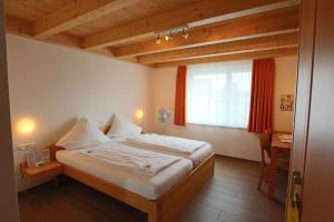 a bedroom with a bed and a desk and a window at Hotel Sunnegässle in Rust