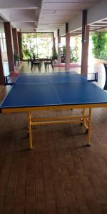 a blue ping pong table in a room with benches at Mersing Merlin Inn in Mersing