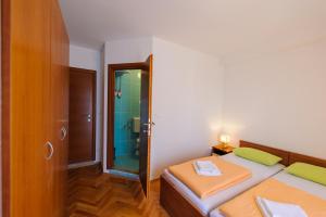 a small bedroom with two beds and a shower at Apartment and Rooms Iva in Split