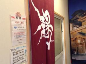 a red curtain with a spider on it next to a door at Lodge Matsuya in Nozawa Onsen