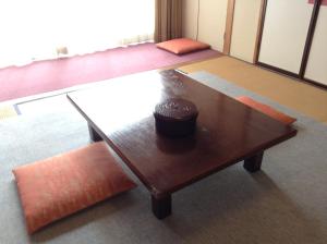 een kamer met een houten salontafel en oranje stoelen bij Lodge Matsuya in Nozawa Onsen