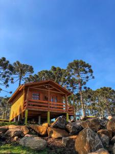 una cabaña de madera sobre una pila de rocas en Pousada Chales Aconchego Serrano, en Bom Jardim da Serra