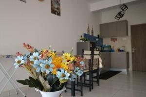 a vase of flowers sitting on a table in a kitchen at AniS Homestay Nilai USIM KLIA INTI Manipal Nilai 3 in Nilai