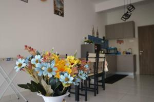 a vase of flowers sitting on a table in a kitchen at AniS Homestay Nilai USIM KLIA INTI Manipal Nilai 3 in Nilai