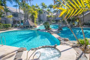 - une piscine d'eau bleue avec des palmiers dans l'établissement The Islander Noosa Resort, à Noosaville