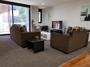 a living room with two couches and a tv at PierPoint 401 in Geelong