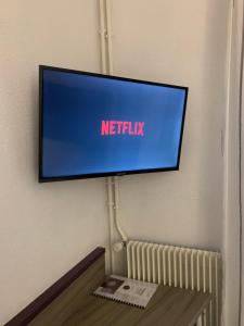 a flat screen tv hanging on a wall at Hôtel O'Nice Saintes in Saintes