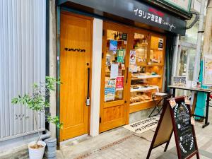 uma loja em frente a uma padaria com uma porta de madeira em Kyunoju em Okayama