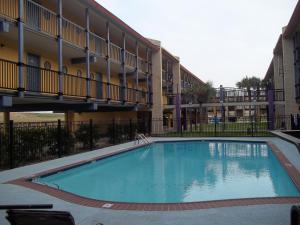 a swimming pool in front of a building at Scottish Inns Galveston in Galveston