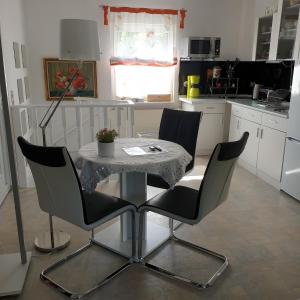een keuken met een tafel met 2 stoelen en een tafel bij Ferienapartment MOHNBLUME in Eichwalde