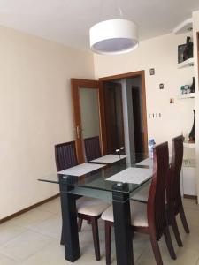 a dining room with a black table and chairs at Apartament Sunny, Варна- център in Varna City