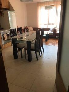 a dining table and chairs in a living room at Apartament Sunny, Варна- център in Varna City