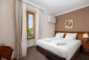 ein Hotelzimmer mit einem Bett mit Handtüchern darauf in der Unterkunft Hotel Le Rive in Nyon