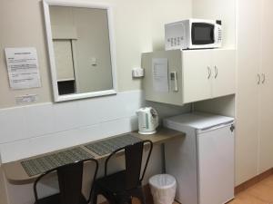 a white microwave sitting on top of a white counter top at Golden Palms Motor Inn in Bundaberg