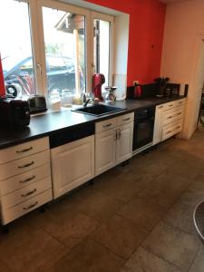 a kitchen with white cabinets and a black counter top at Chez leo in Marboué +5 photos