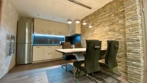 a kitchen with a table and chairs and a brick wall at Paradise Swing Apartment Sofia in Sofia