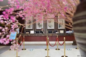 un hombre sentado en un bar con flores rosas en Beijing Post Hotel, en Beijing