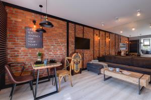 a living room with a couch and a brick wall at Apartamenty Colobrzeg Loft in Kołobrzeg