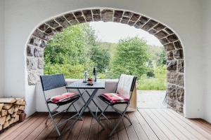 una mesa y sillas en una terraza con un arco en Ferienwohnung VILLA FRÜBING, en Ilmenau